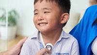 Doctor checking boy’s heartbeat.